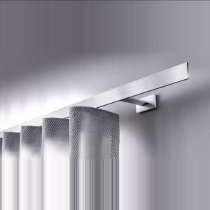 Nahaufnahme des Interstil Vorhangschienensystems „Codex“. Eine flache, minimalistische Vorhangschiene aus hochwertigem, matt gebürstetem Aluminium, die mit einem eckigen Wandhalter montiert ist. An der Schiene hängt ein heller Wellenvorhang mit einer dezenten Netzstruktur. Das Design wirkt modern und geradlinig.